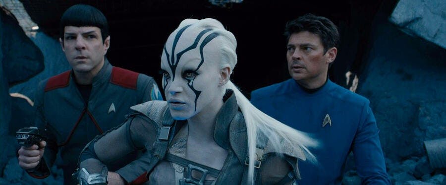 Jaylah leads Spock and Bones who are behind her in an apprehensive and defensive stance amid the rubble in Star Trek Beyond