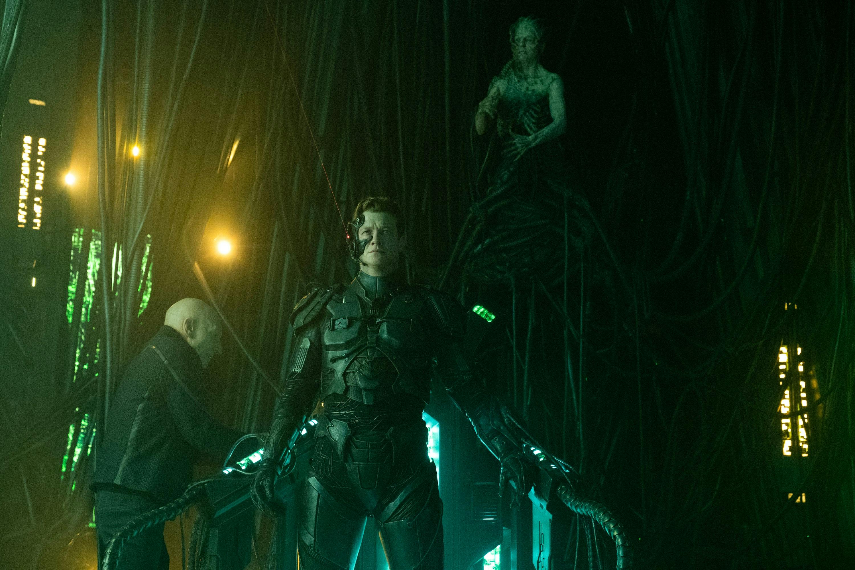 On the Borg Cube, Jean-Luc rushes to a console as Jack Crusher as Vox stands assimilated with the Borg Queen controlling him from above in 'The Last Generation'