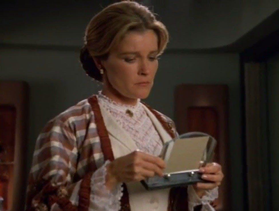 As a governess in a holo-novel, Janeway looks down at an artifact in 'Persistence of Vision'