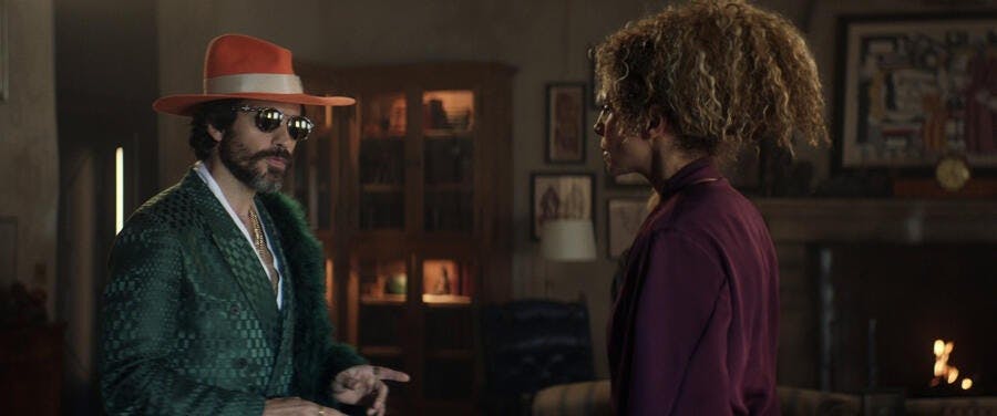 Cristobal Rios in a green suit, sunglasses, hat, and boat faces Raffi in 'Stardust City Rag'