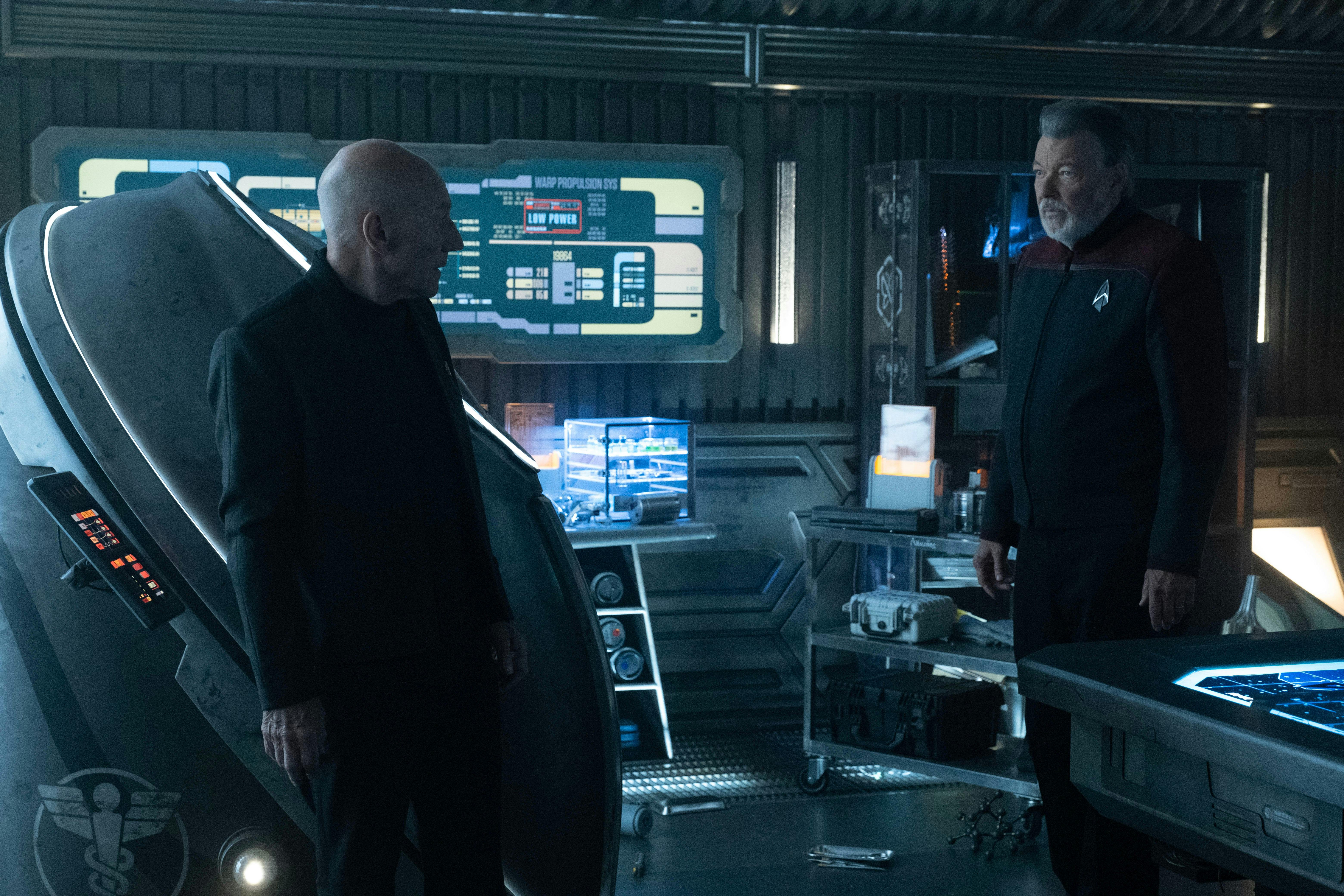 Admiral Jean-Luc Picard and Captain Will Riker shared concerned glances as they stand in front of Beverly's medical stasis pod on Star Trek: Picard