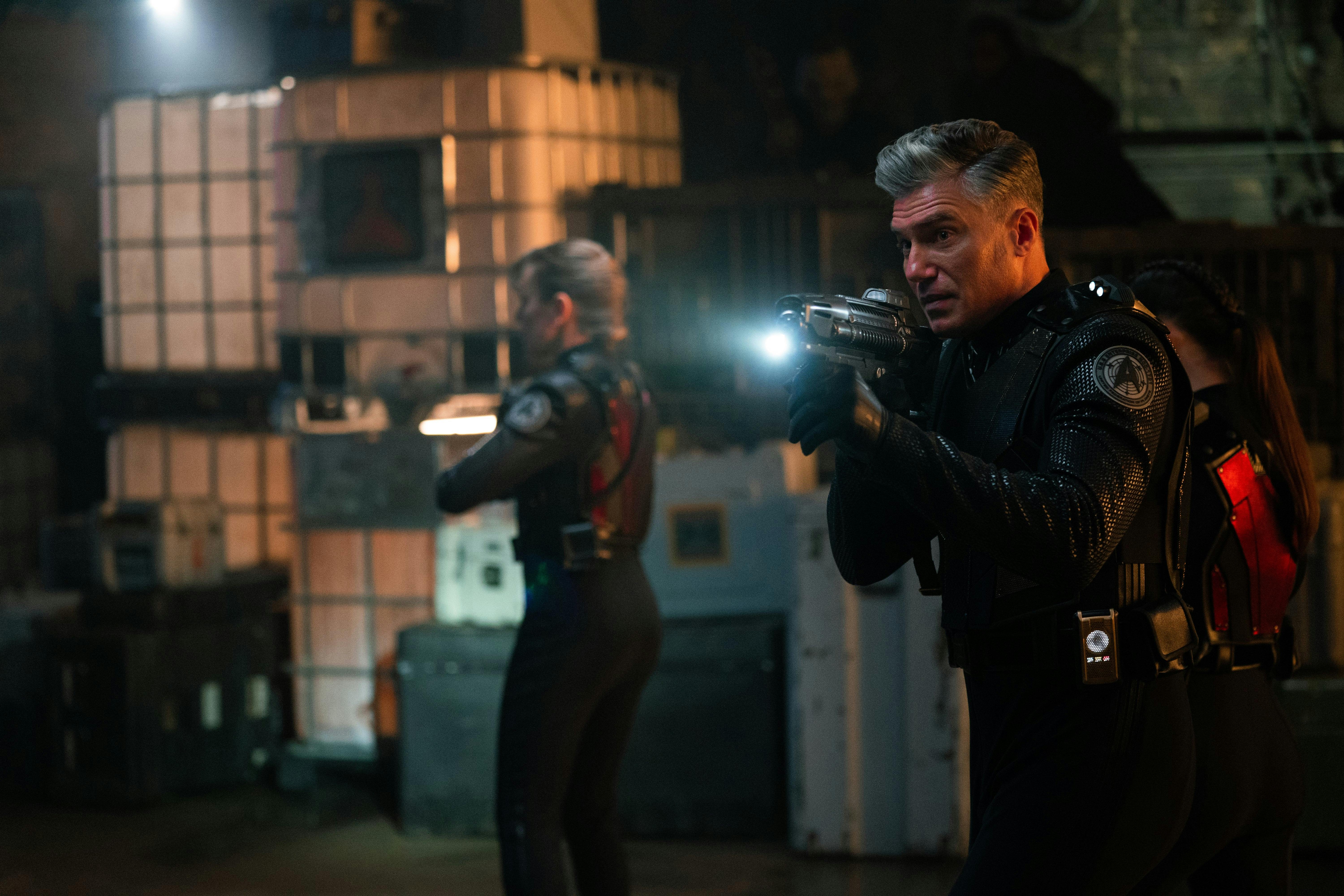 Pike (Anson Mount) is wearing tactical gear and holding a phaser rifle.