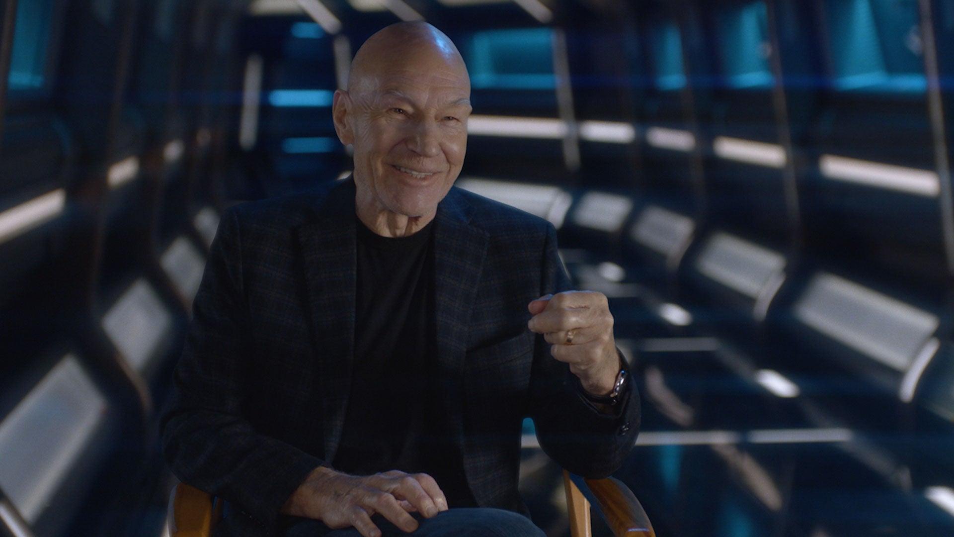 Sir Patrick Stewart smiles as he raises his fist up in cheer
