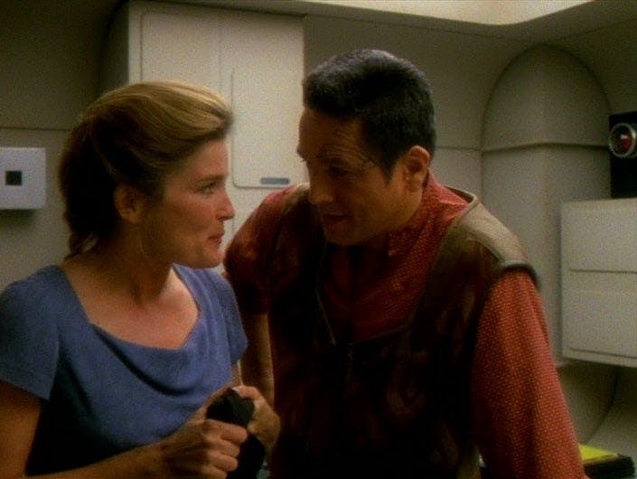 Janeway and Chakotay, dressed in civilian clothes, look at each other, in 'Resolutions'