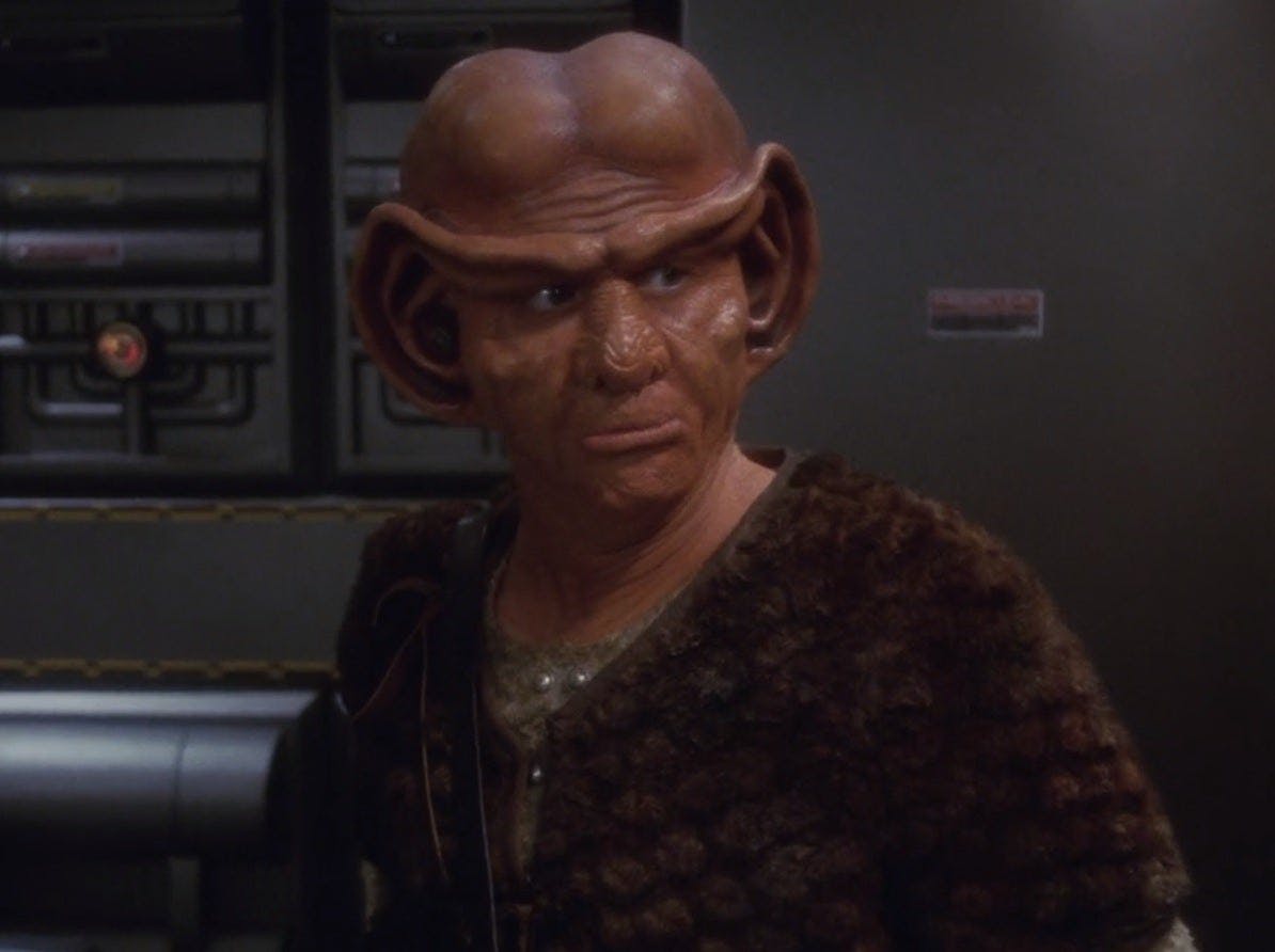 Close-up of the Ferengi pirate Krem looking over his left shoulder in 'Acquisition'