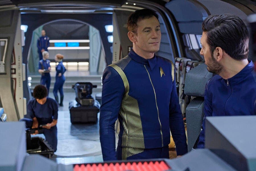 Aboard a shuttle, Gabriel Lorca talks to Ash Tyler while Michael Burnham packs her supplies in the background in 'Lethe'
