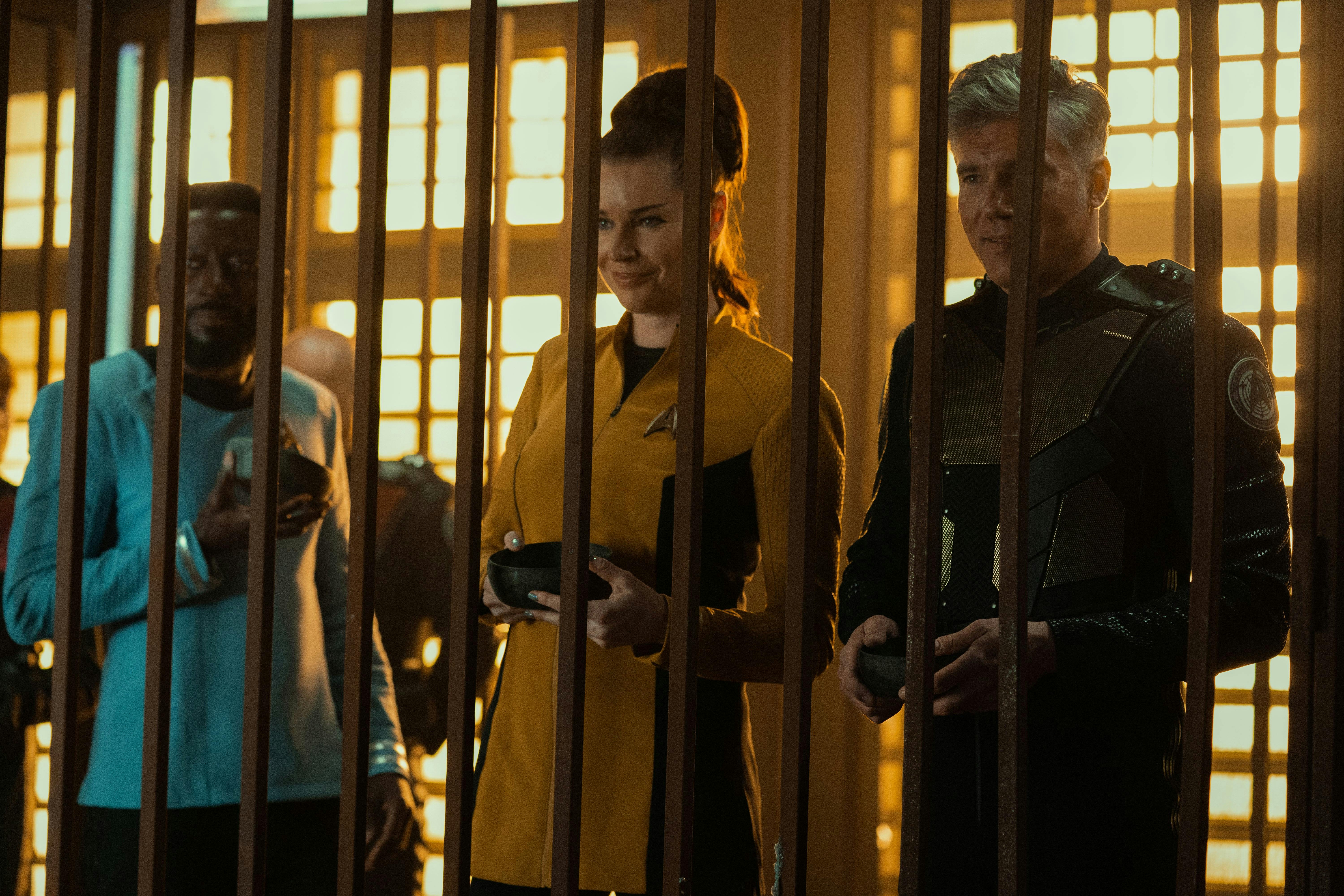 Dr. M'Benga (Babs Olusanmokun), Number One (Rebecca Romijn), and Pike (Anson Mount) stand in a prison cell.