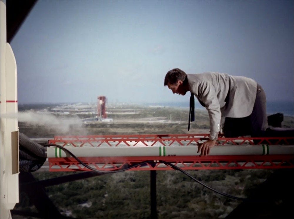 Mr. Seven tries to sabotage the nuclear rocket. An image of launch facilities at Kennedy Space Center is used for the background. 