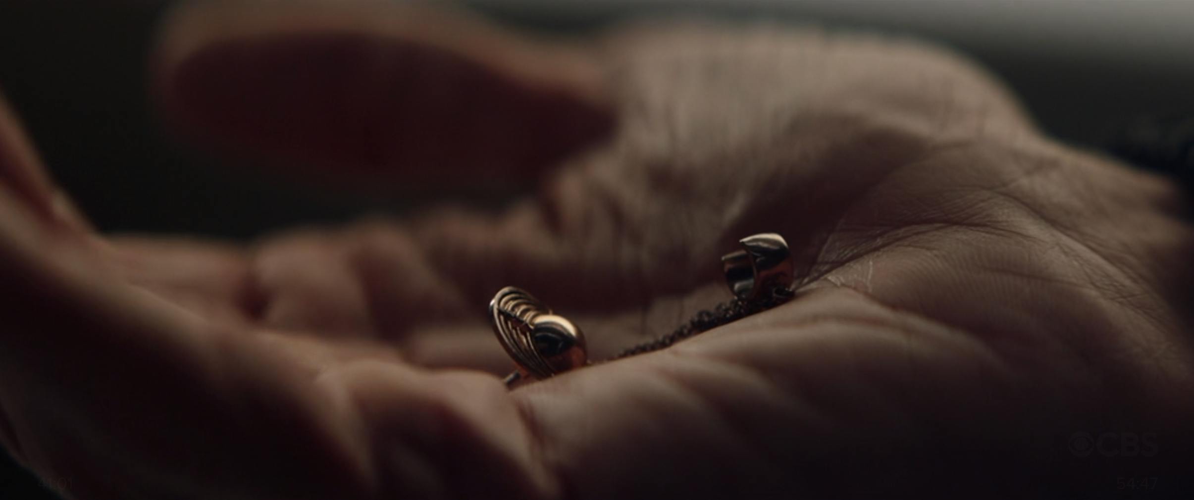 A close-up of Ro Laren's Bajoran earring in the palm of Picard's hand