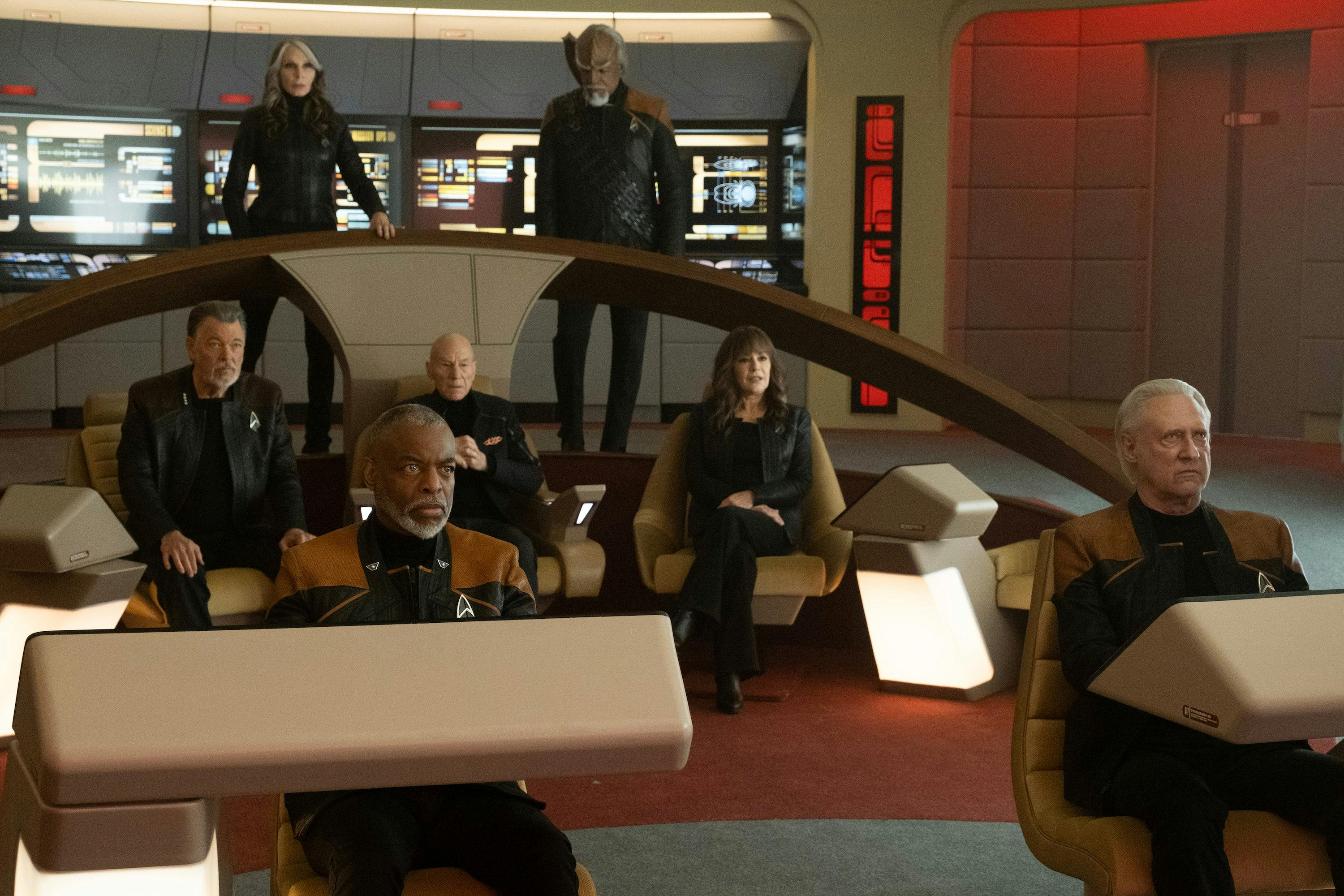 Beverly Crusher and Worf at the arch of the Enterprise-D bridge, at command are Will Riker, Jean-Luc Picard, and Deanna Troi, with Geordi La Forge at the helm and Data at tactical in 'The Last Generation'