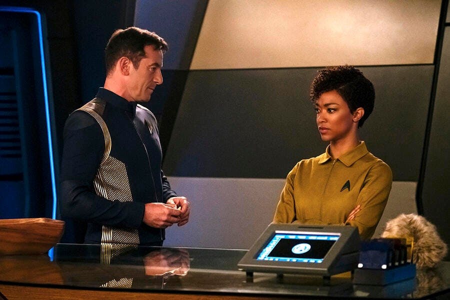 Gabriel Lorca looks over at a stoic Michael Burnham in 'Context is for Kings'