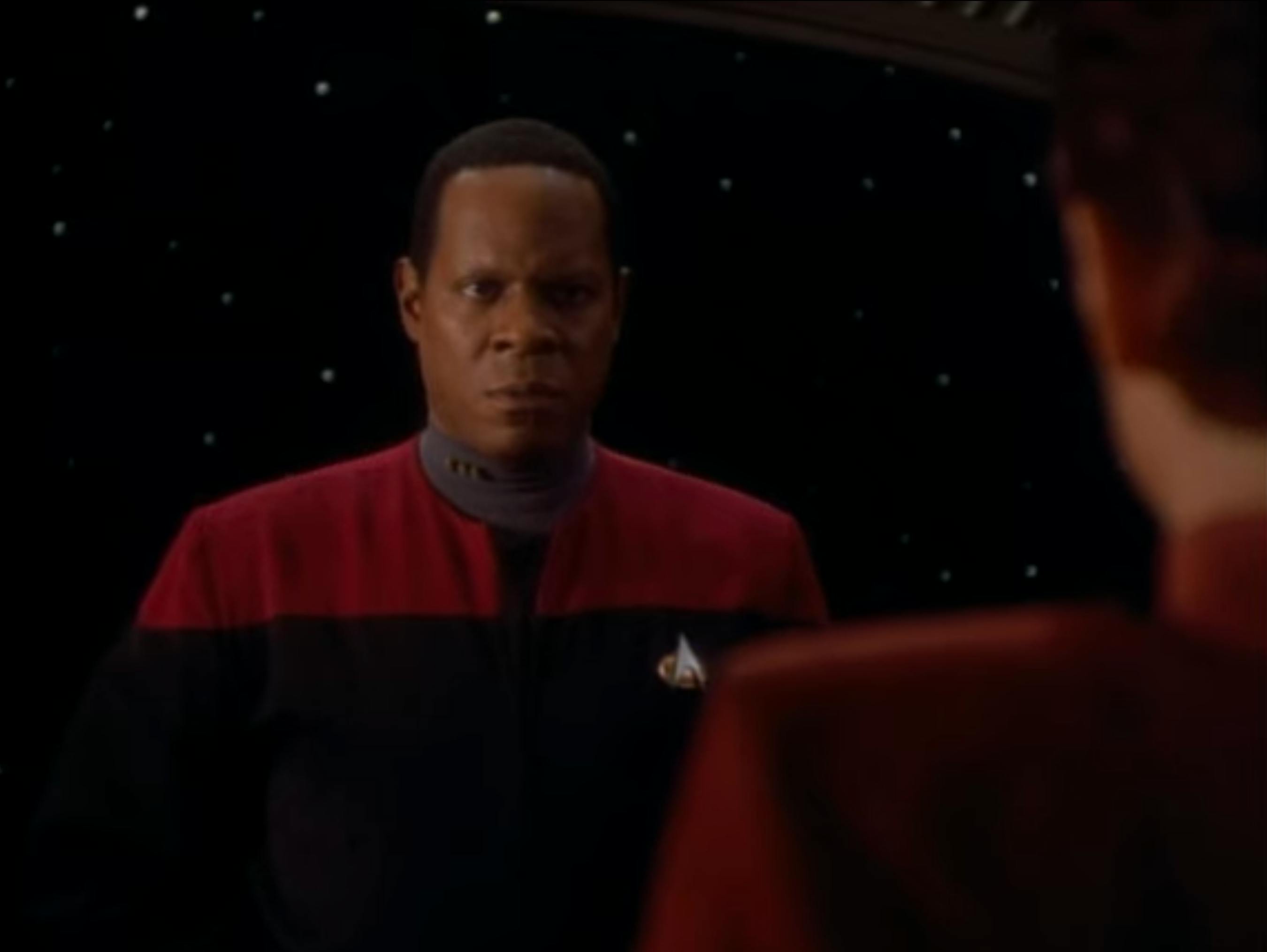 Sisko looks at Kira, whose back faces us, on Star Trek: Deep Space Nine