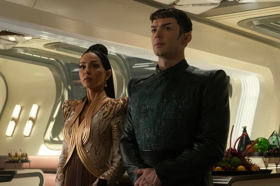 T'Pring and Spock, in formal attire, stand side-by-side to greet her parents to their Vulcan V'Shal engagement dinner in Pike's captain's quarters in 'Charades'