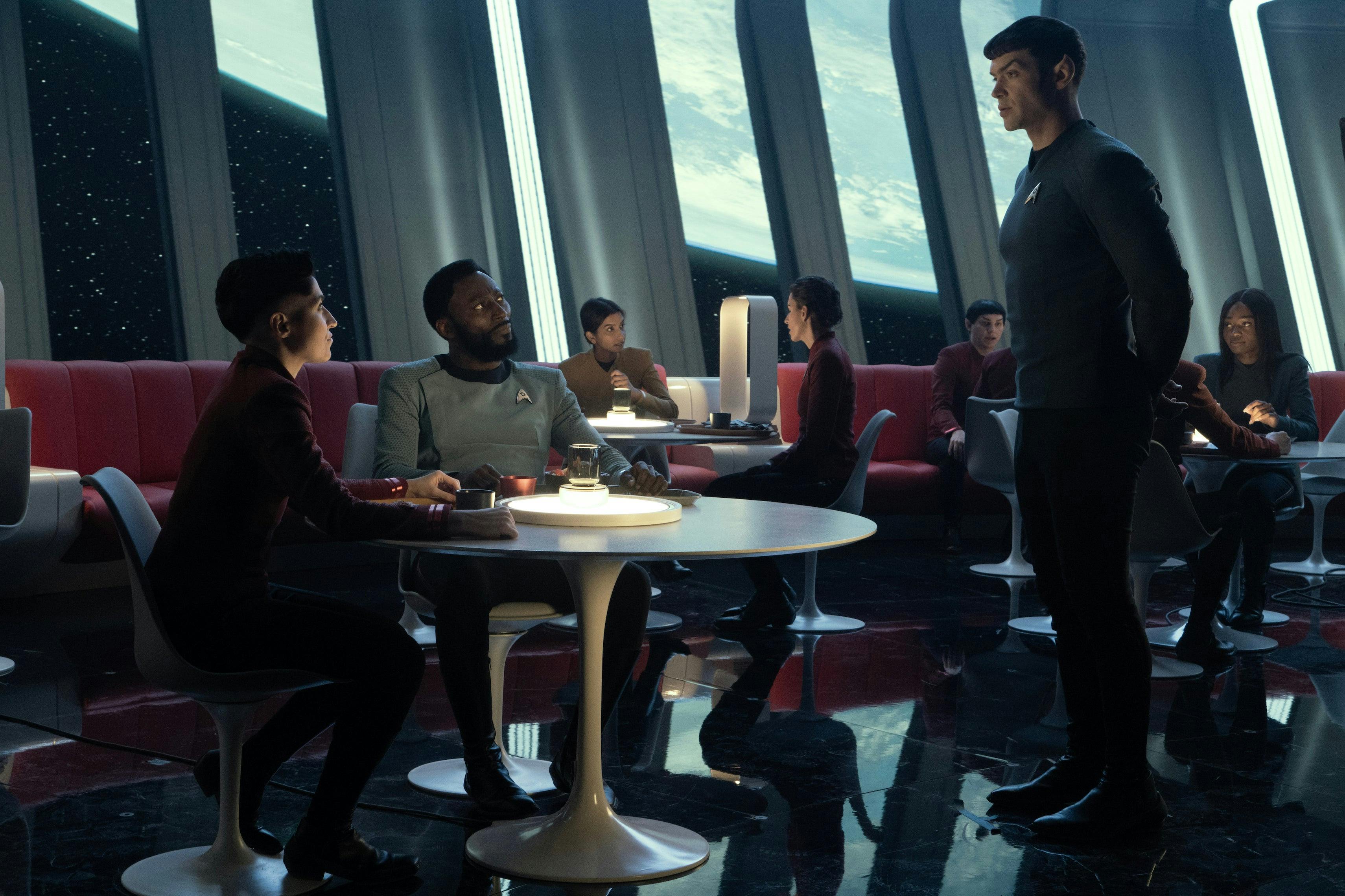 Spock approaches a seated Erica Ortegas and M'Benga in the crowded mess hall in 'Ad Astra per Aspera'