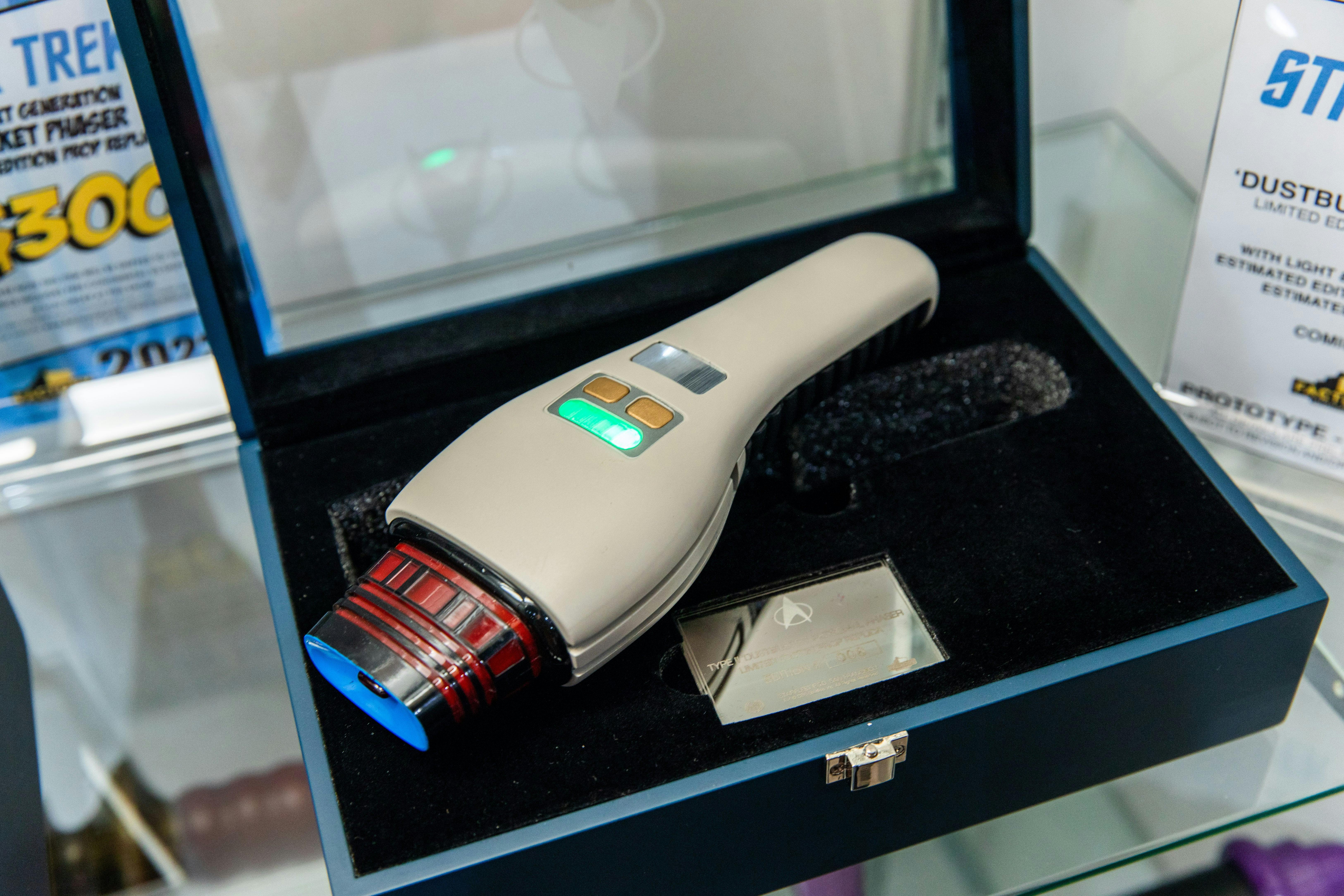A phaser replica is in a case.