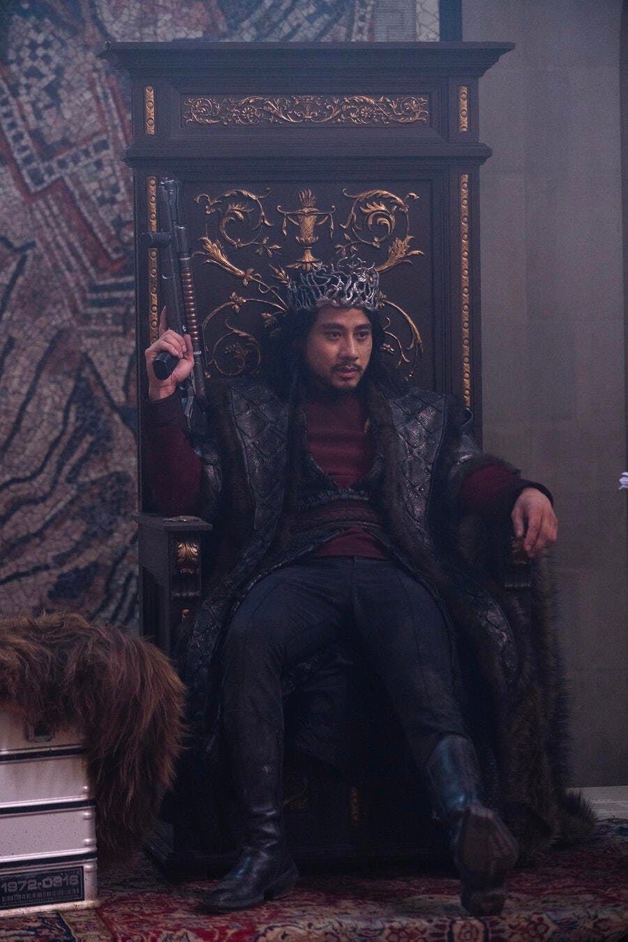The High Lord of Kalar and Pike's former Yeoman, Zacarias, wearing a stylized crown, sits on the palace throne in 'Among the Lotus Eaters'
