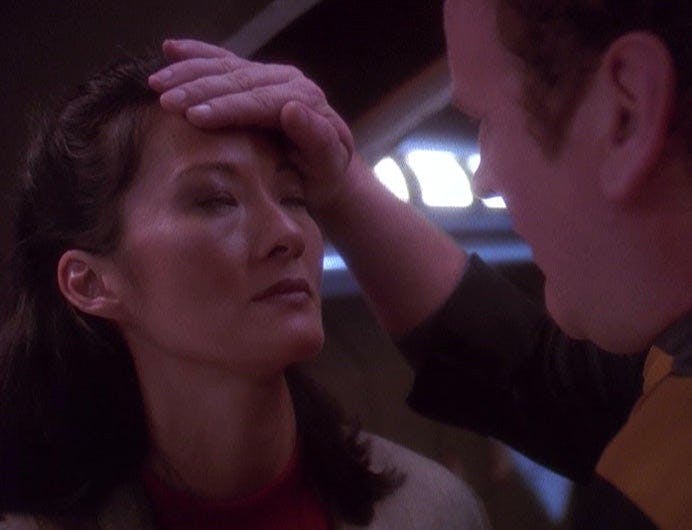 O'Brien puts his hand to Keiko's forehead to see if she has a temperature in 'The Assignment'