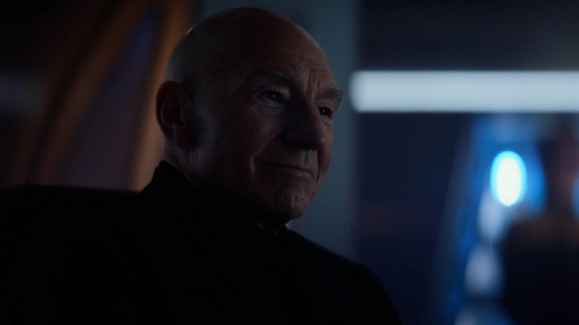 Admiral Jean-Luc Picard sits on the Bridge of the Titan and smiles