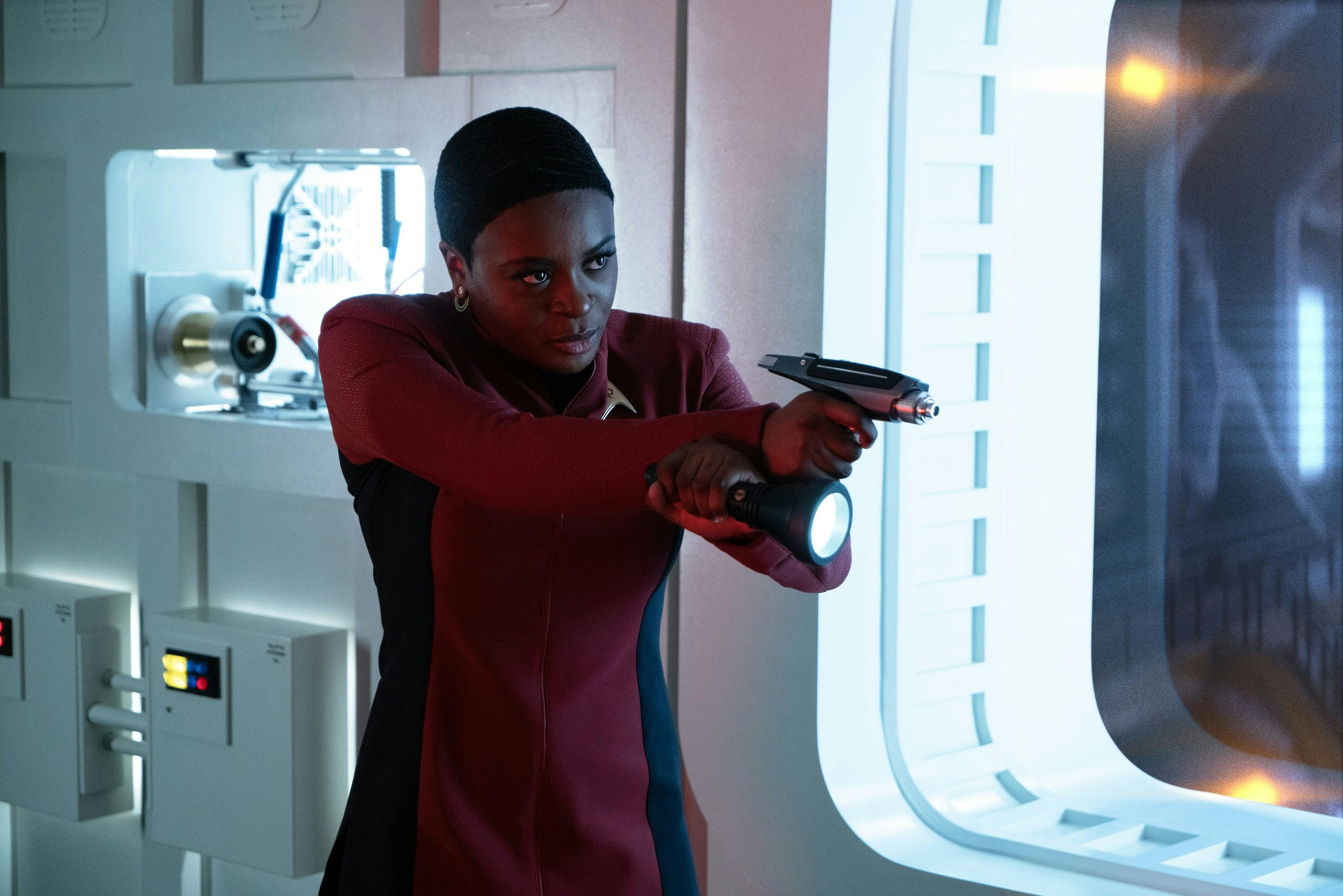 Uhura stands defensively in Engineering with her phaser and flashlight raised in front of her in 'Lost In Translation'