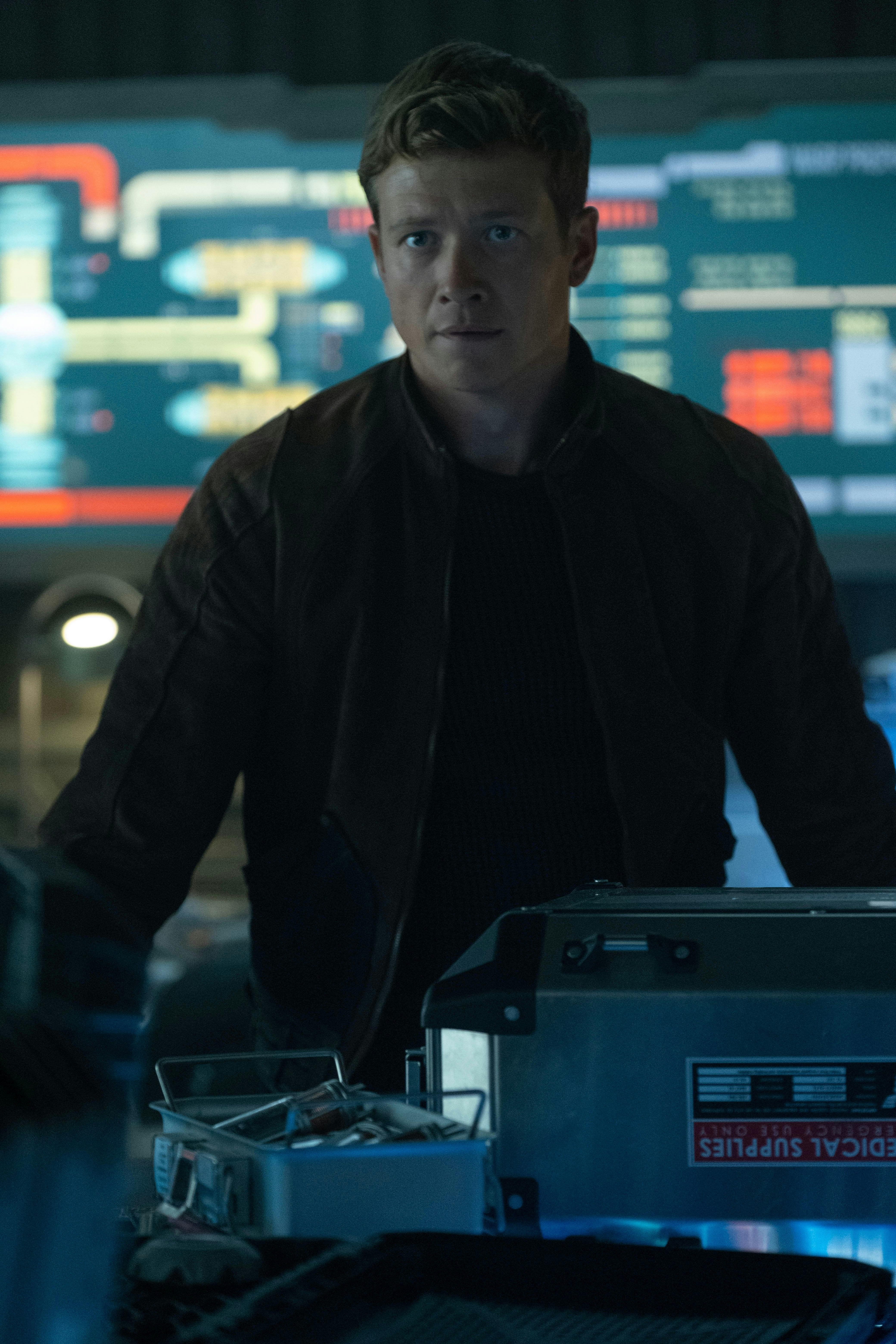 Jack Crusher stands in the command bay of the Eleos XII with the viewscreen behind him on Star Trek: Picard