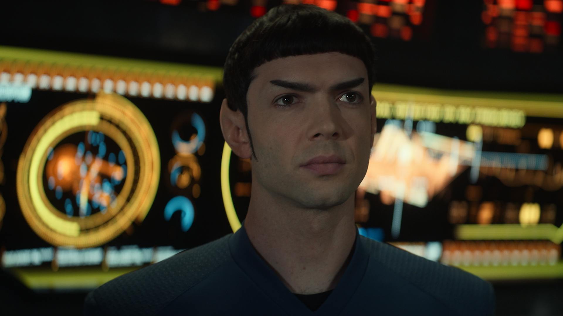 Spock (Ethan Peck) looks at the viewscreen on which the Romulan commander is displayed.