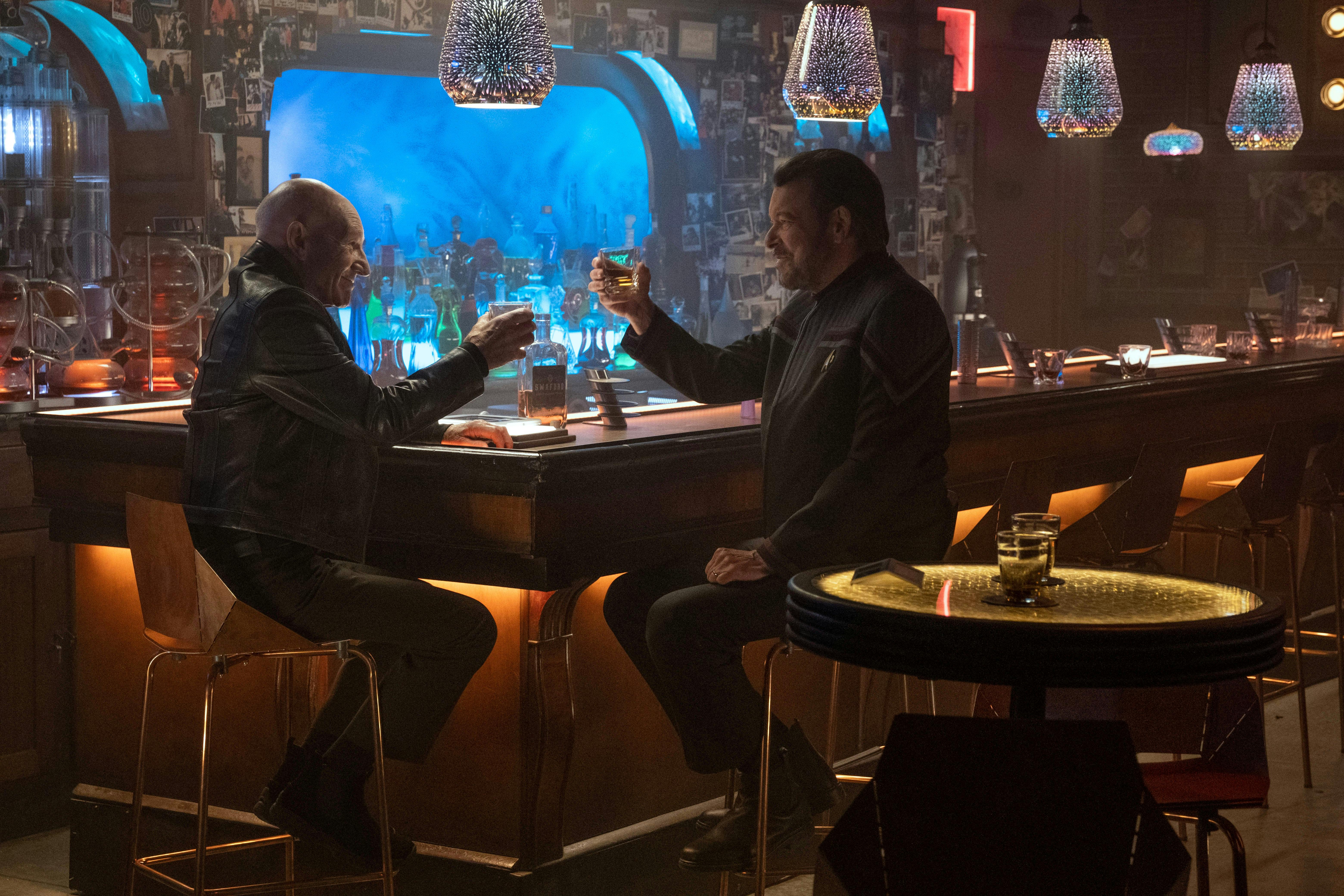 Picard and Riker raise their glasses in celebration in a flashback at 10 Forward