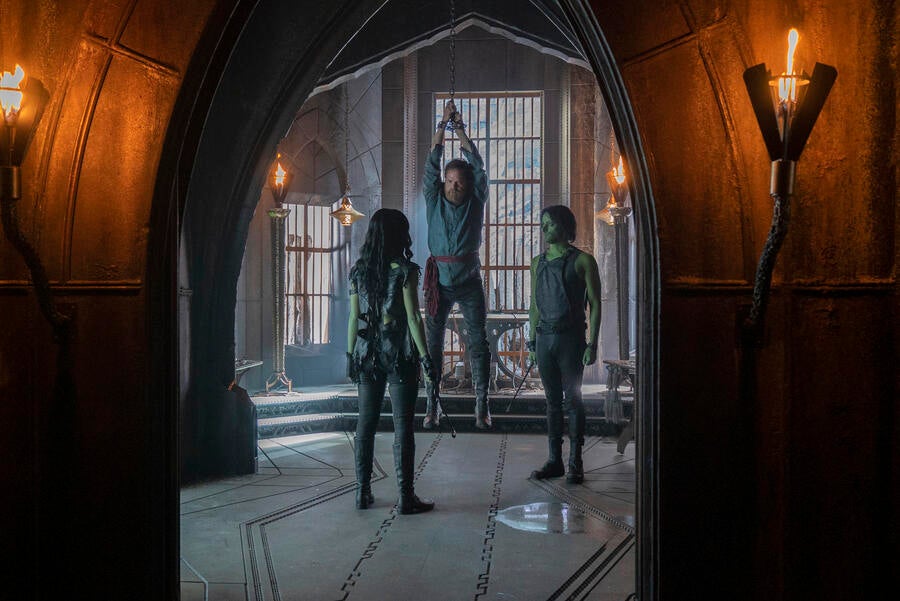 Harry Mudd hangs from some chains while facing two Orions in 'The Escape Artist'