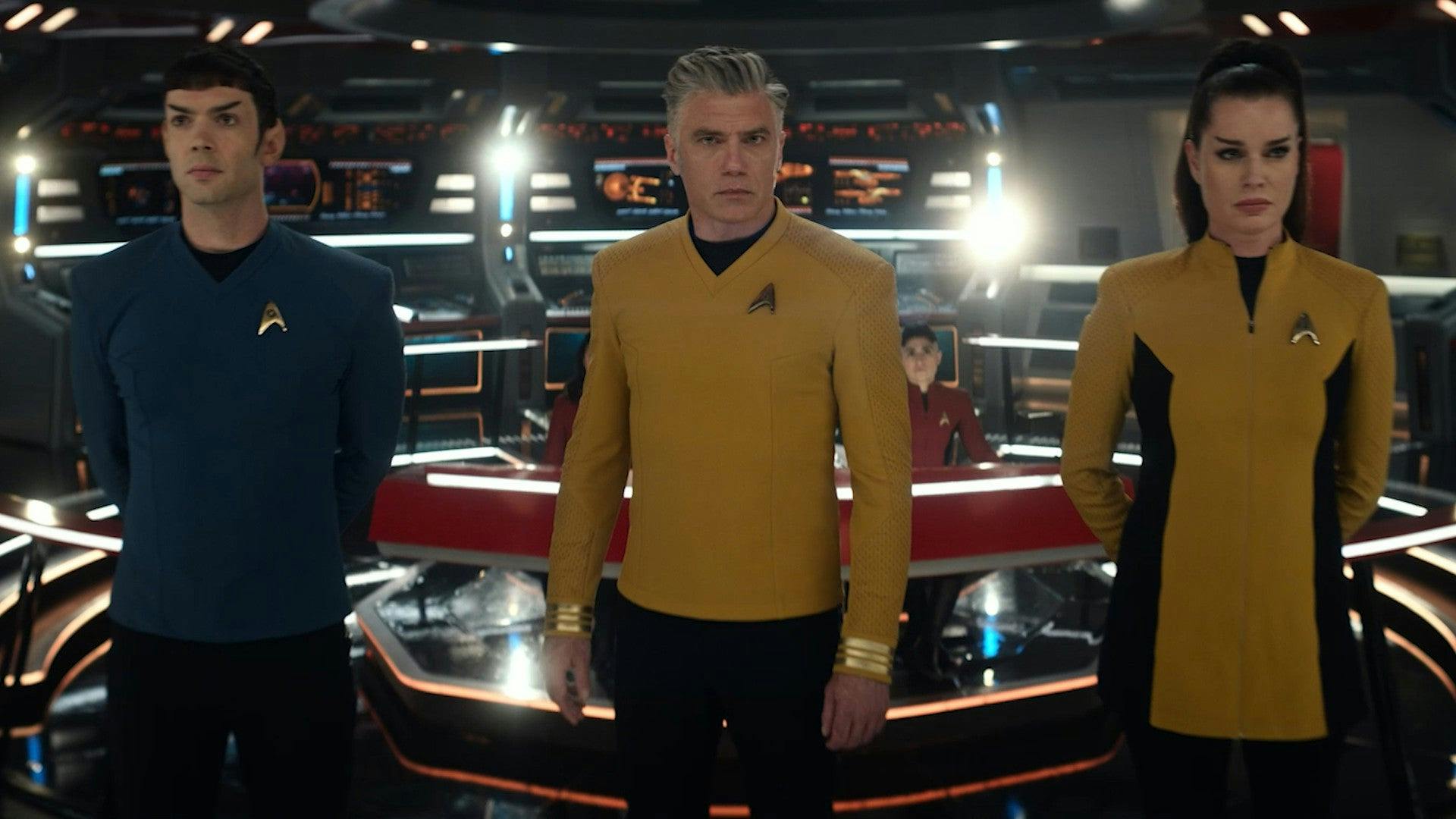 A concerned Pike, flanked by Spock and Una, look ahead at the viewscreen on the bridge of the Enterprise in 'Subspace Rhapsody'