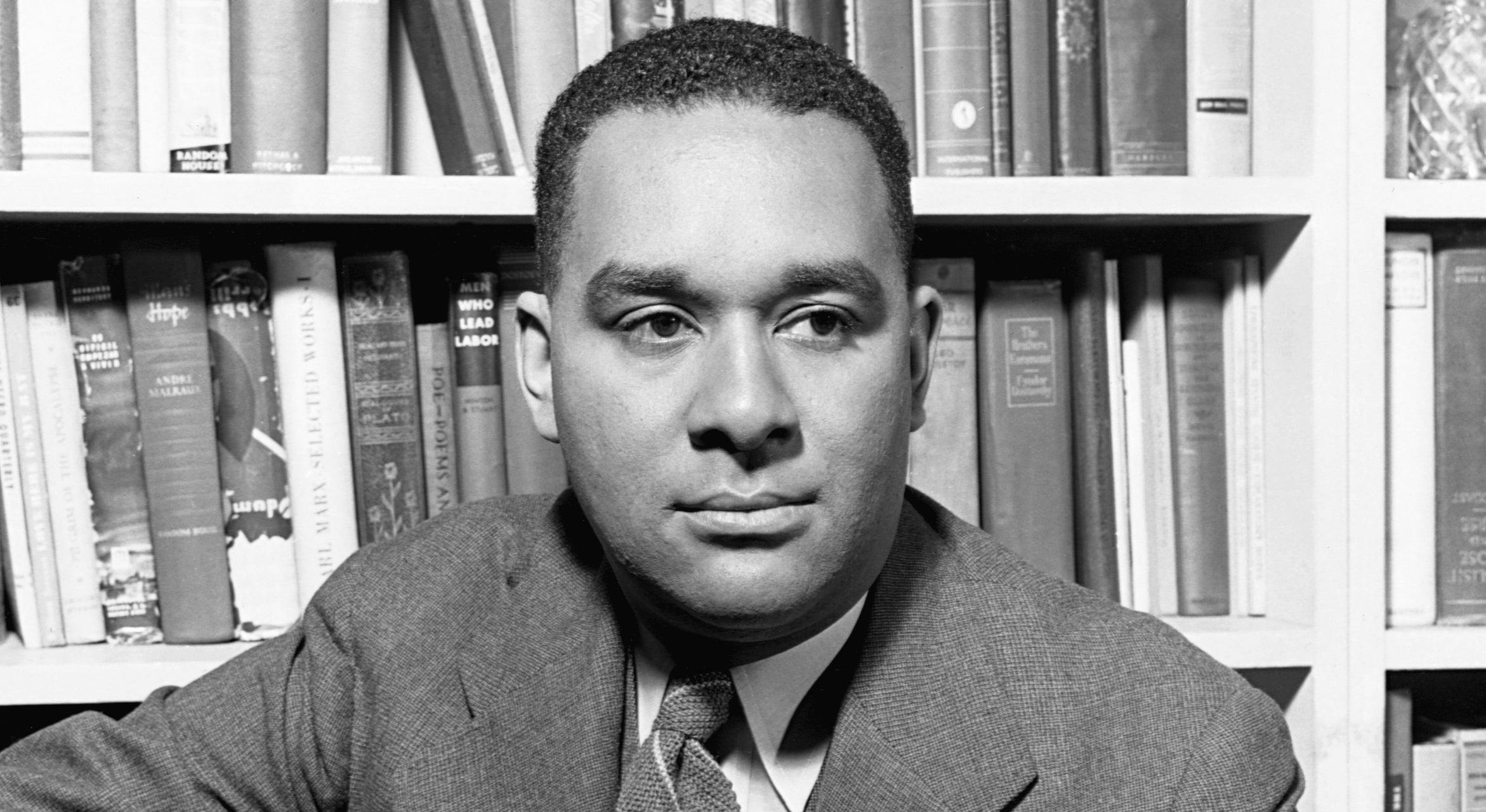Portrait of Richard Wright in front of a shelf of books