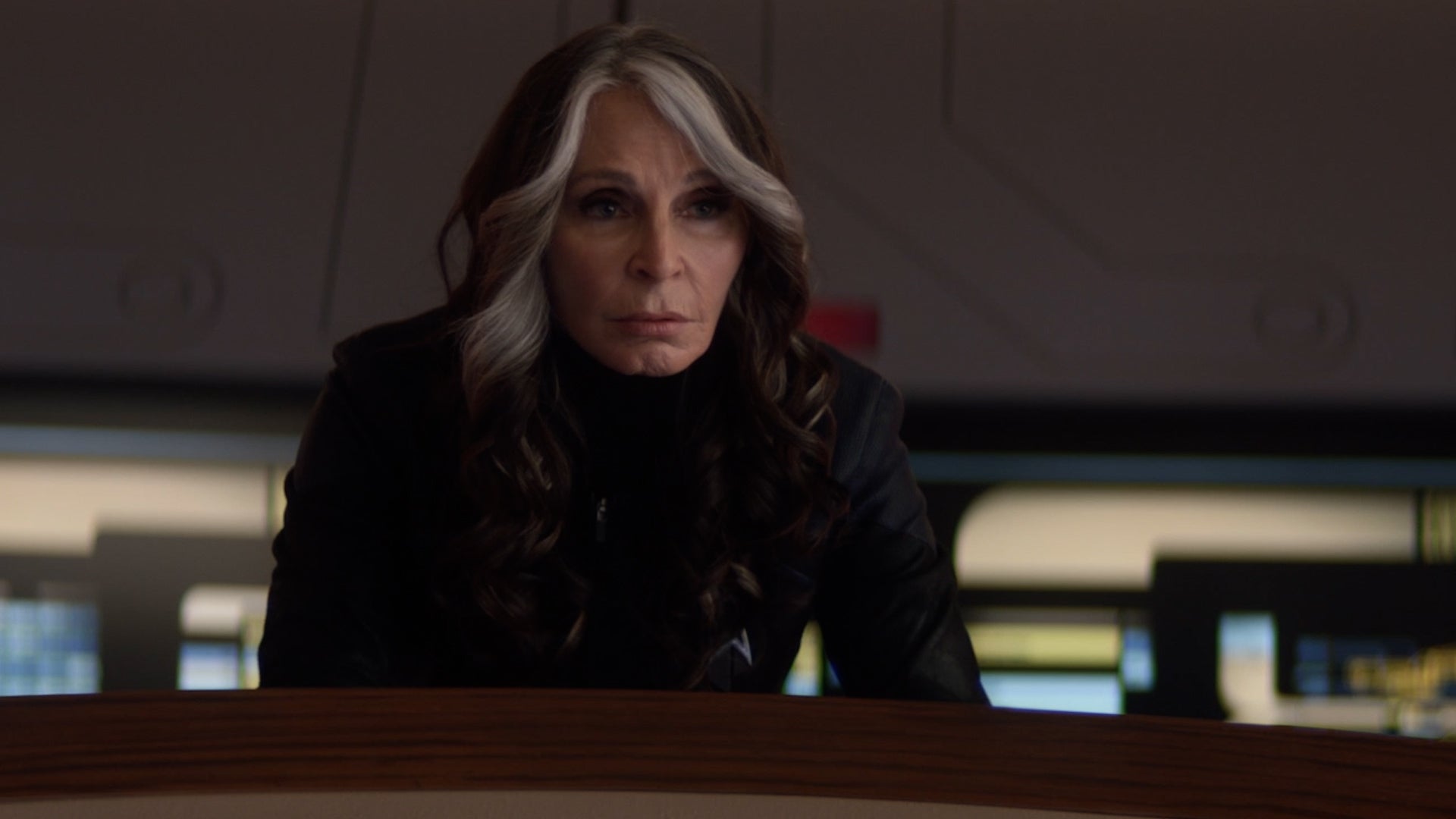 Beverly Crusher leans forward staring intently at the viewscreen ahead in 'The Last Generation'