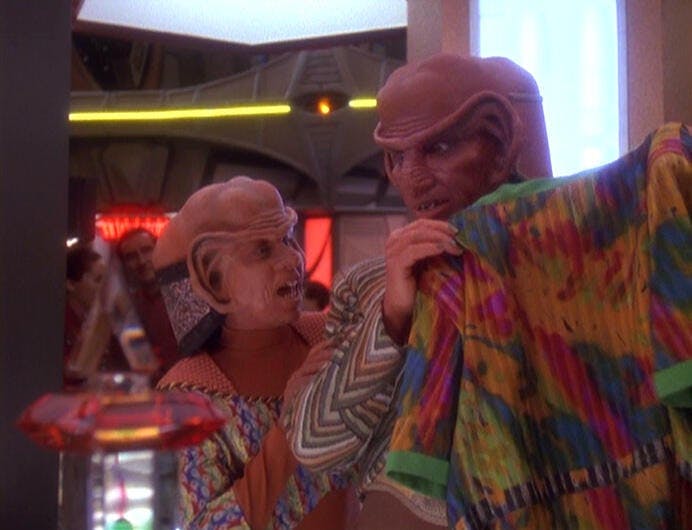 Rom lifts up a sweater to Nog's excitement at Quark's Bar in 'Little Green Men'