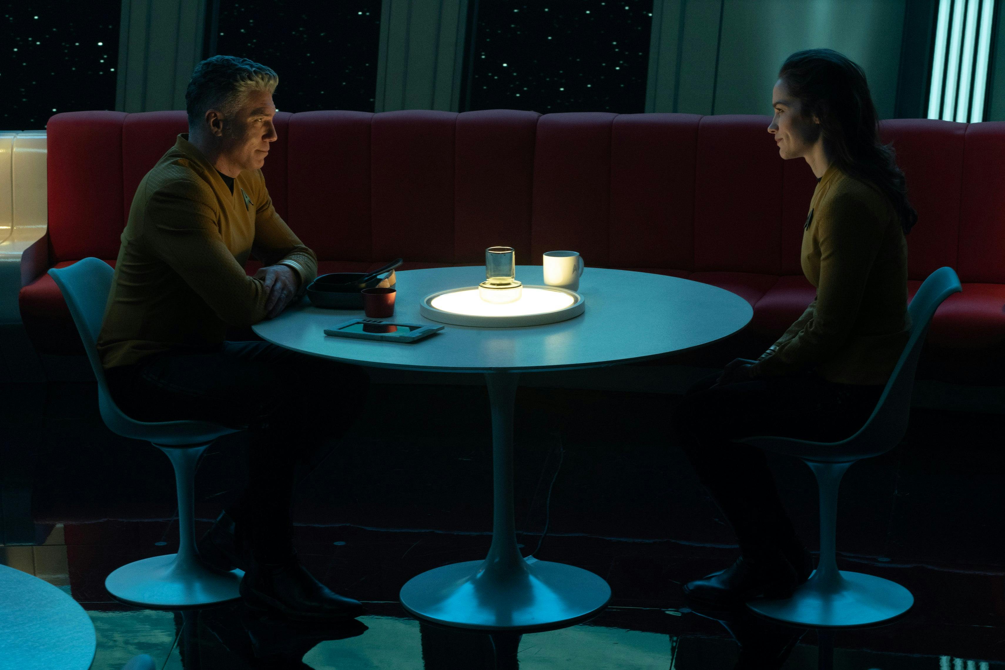 Captain Pike and Captain Batel sit in the mess hall by candle light in 'Ad Astra per Aspera'
