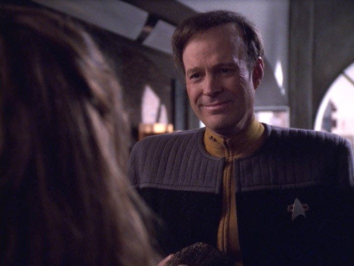 Lt. Barclay smiles at Commander Troi.