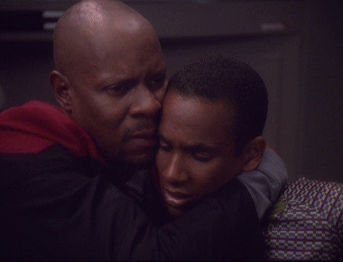 Captain Sisko embraces his son, Jake.