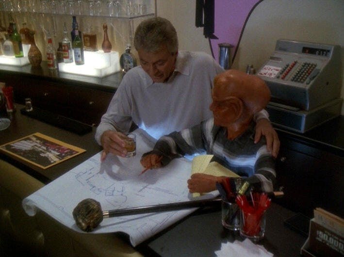 Vic Fontaine and Nog work on blueprints to expand the holosuite casino in 'It's Only A Paper Moon'