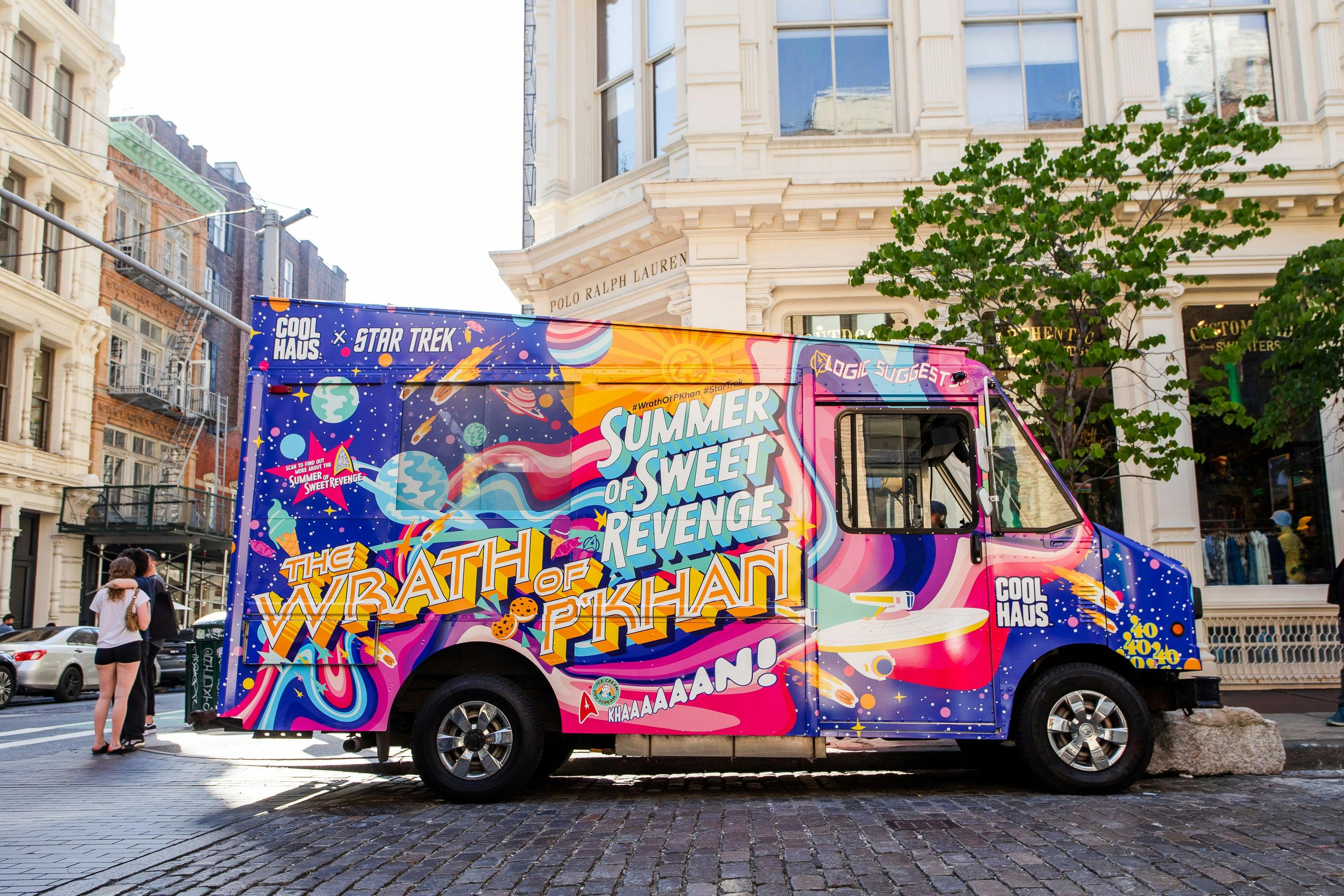 The ice cream truck, which is covered in bright colors and reads "The Summer of Sweet Revenge" and "The Wrath of P'Khan", sits parked on the street.