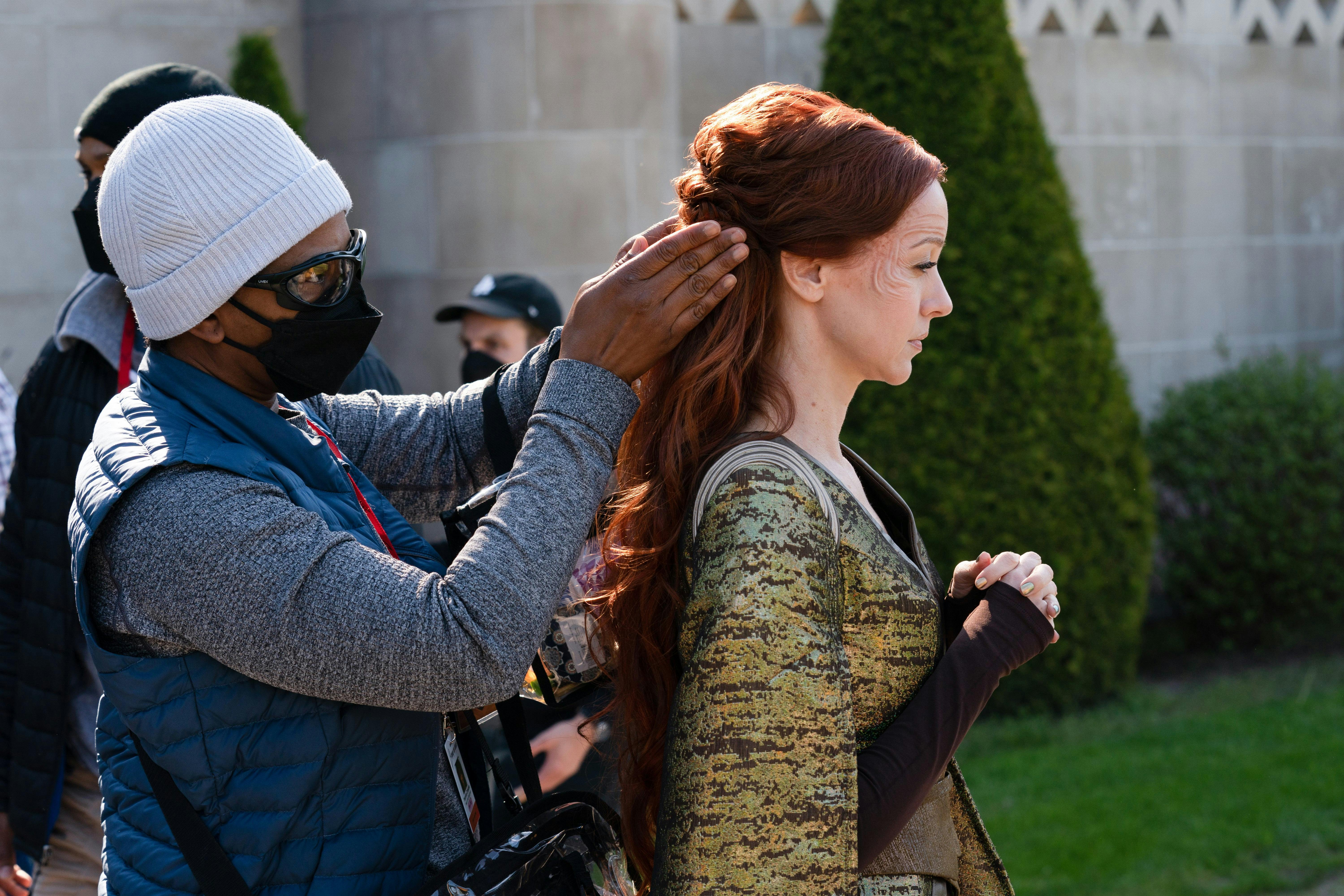 A crew member fixes Lindy Booth's (Alora) hair before a shot.