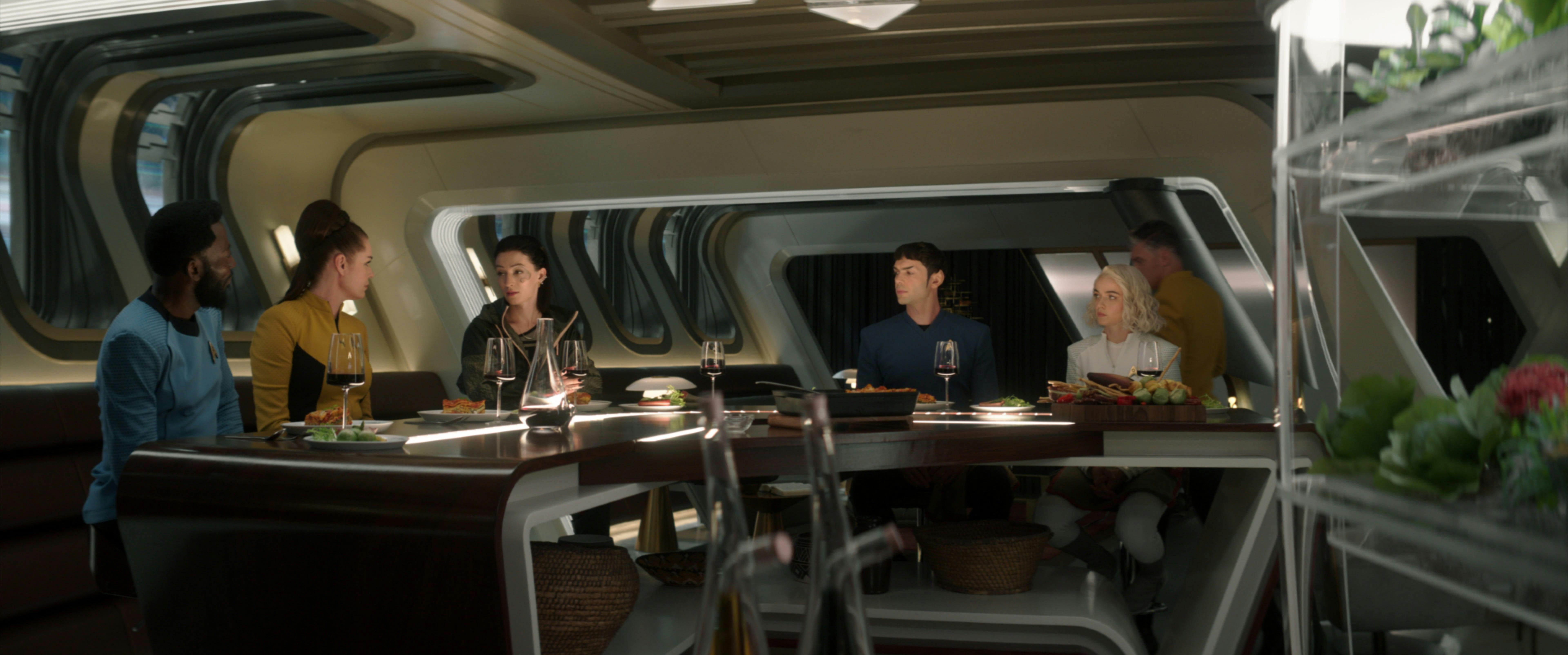 The crew of the U.S.S. Enterprise sits around a table in Pike's quarters
