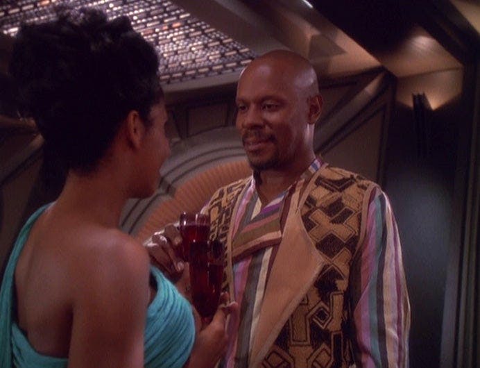 Ben Sisko gazes lovingly at Kasidy Yates while raising a glass in 'The Way of the Warrior'