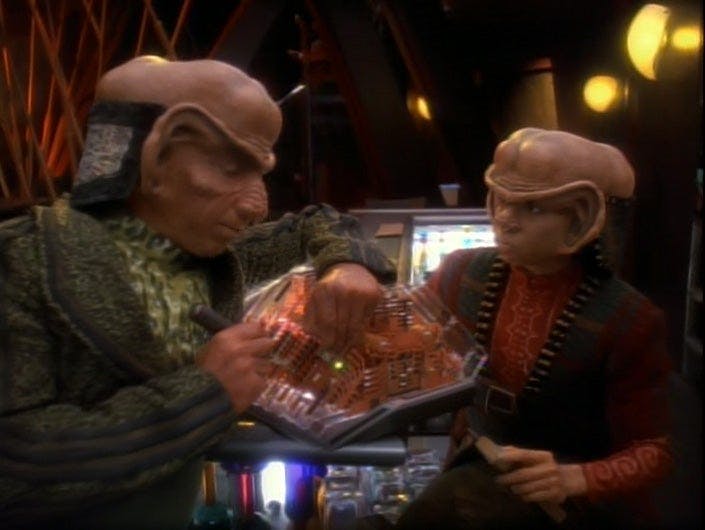 Rom and Nog attempt to fix some machinery in Quark's bar on Deep Space 9.