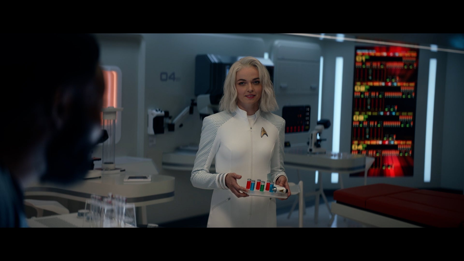 Strange New Worlds' Nurse Chapel stands in the med bay holding a tray of viles. 