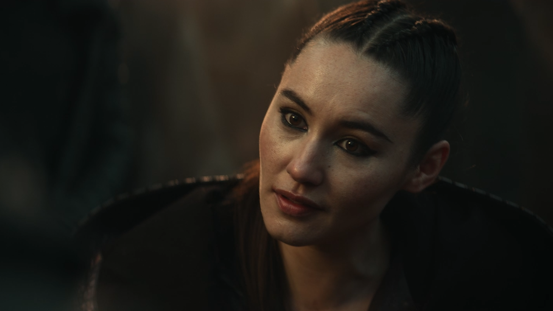 Close-up of a civilian-dressed La'An sitting across a Klingon in 'The Broken Circle'