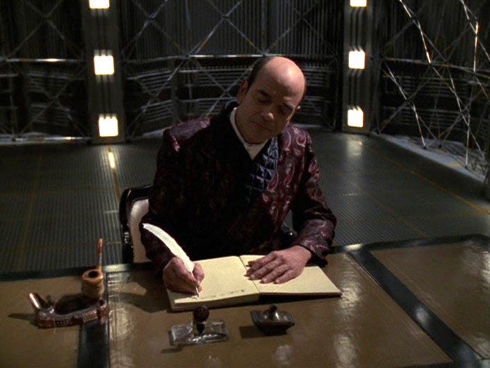 The Doctor, dressed in a smoking jacket, works on his hono-novel taking a quill to parchment in 'Author, Author'