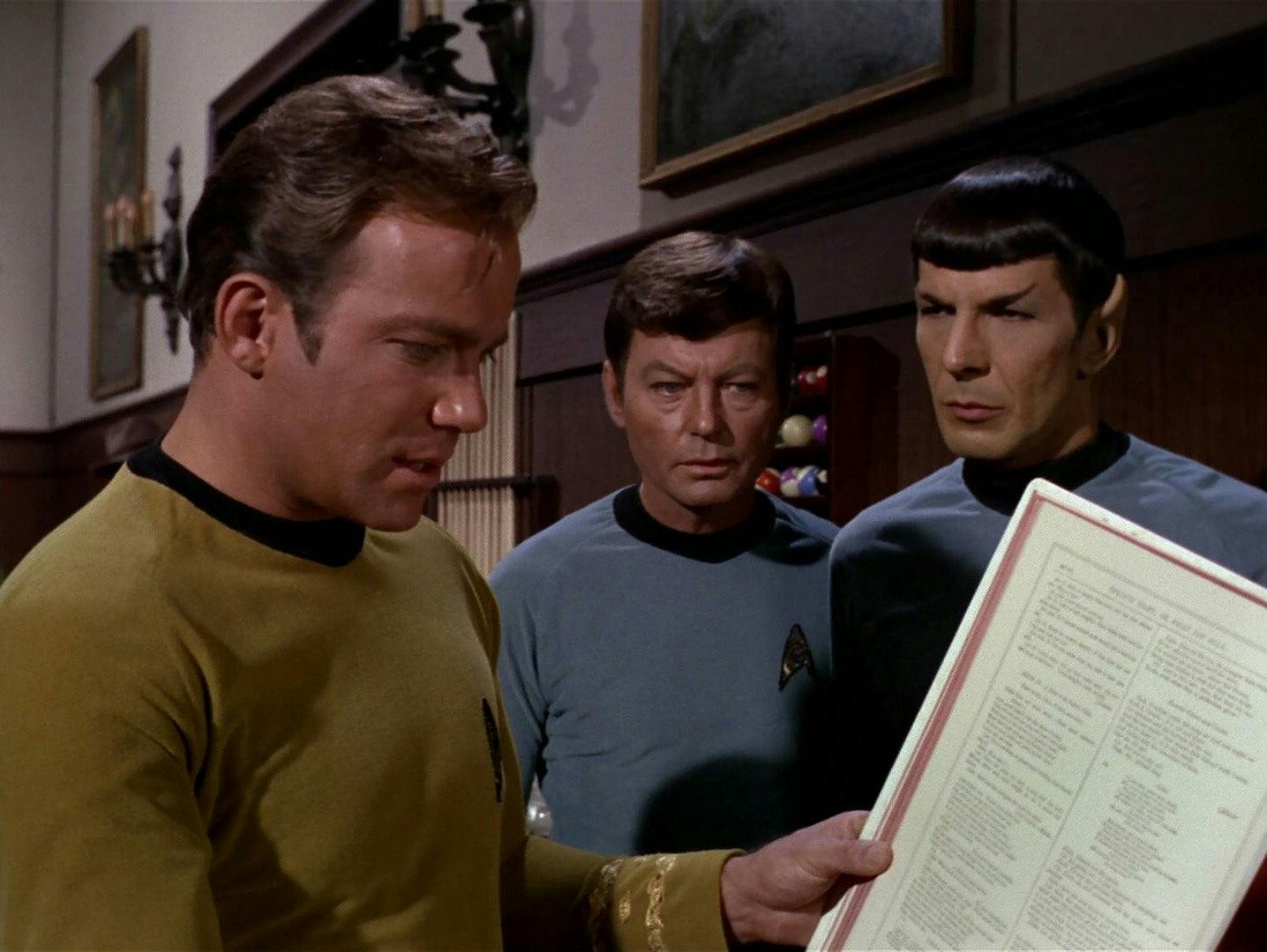Kirk, McCoy, and Spock look at The Book in A Piece of the Action