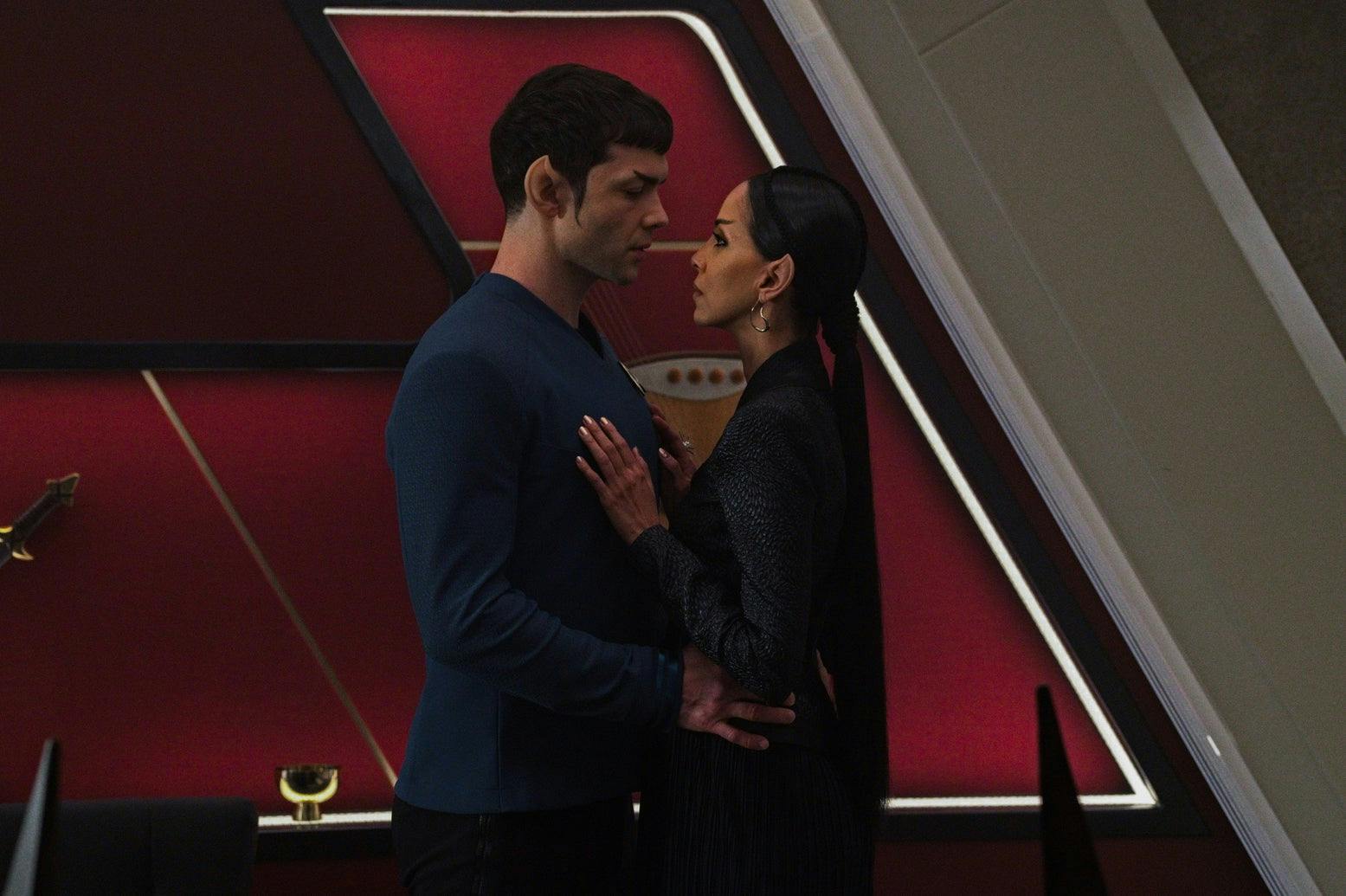Spock and T'Pring (Strange New Worlds) stand close together, with T'Pring's hands on Spock's chest.
