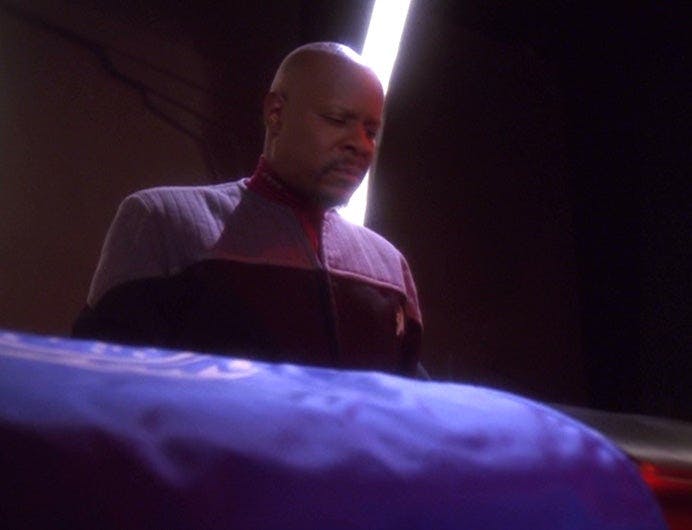 Sisko remorsefully stands over Jadzia Dax's coffin on Star Trek: Deep Space Nine