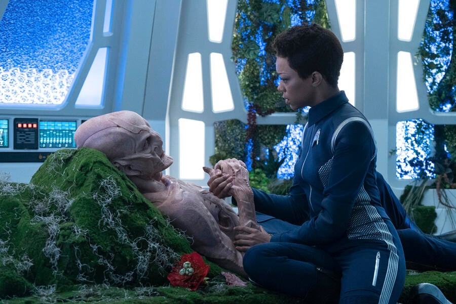 Michael Burnham at Saru's bedside holding his hand in 'An Obol for Charon'