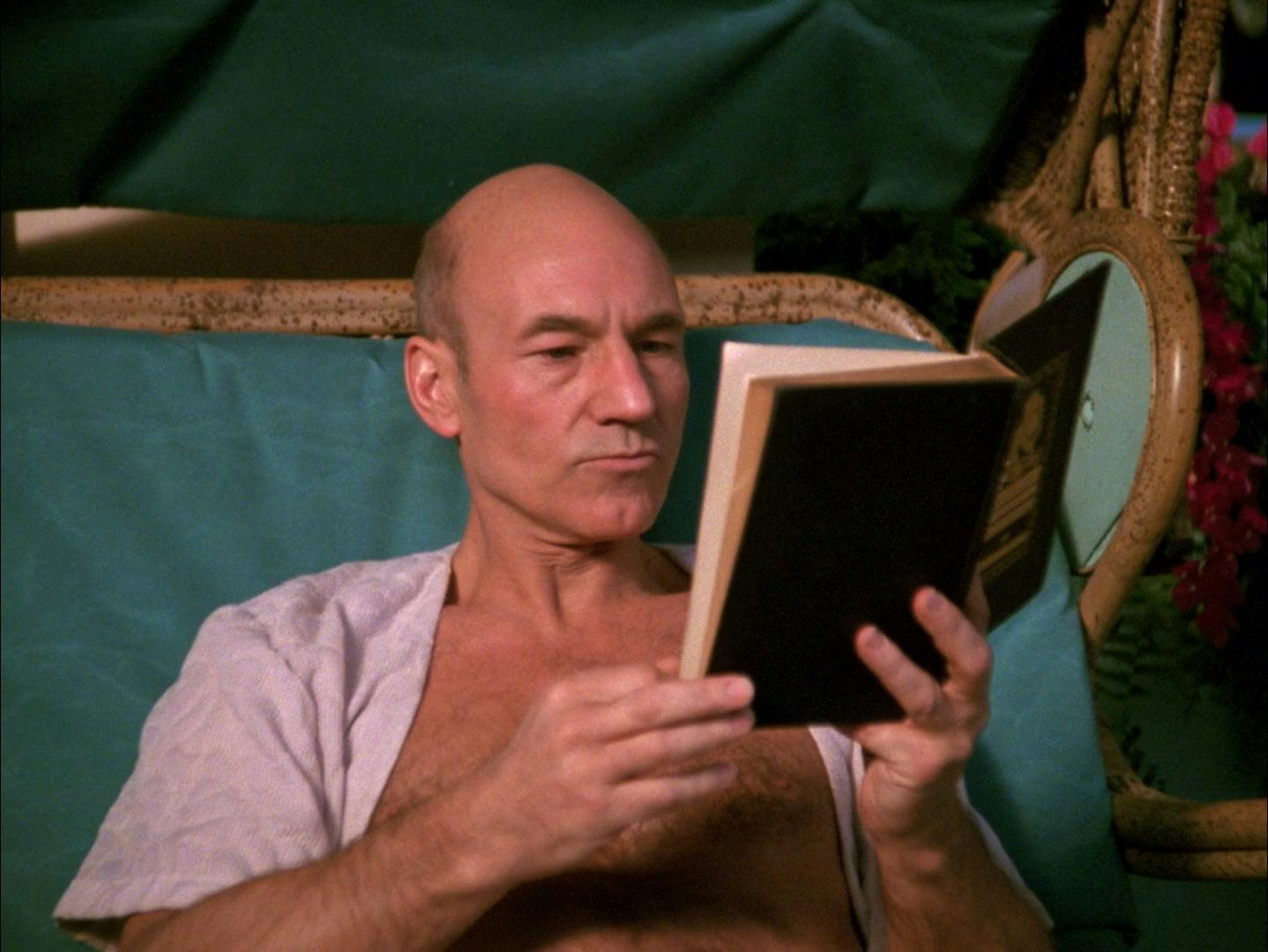 Jean-Luc Picard reads a book as he relaxes on Risa.