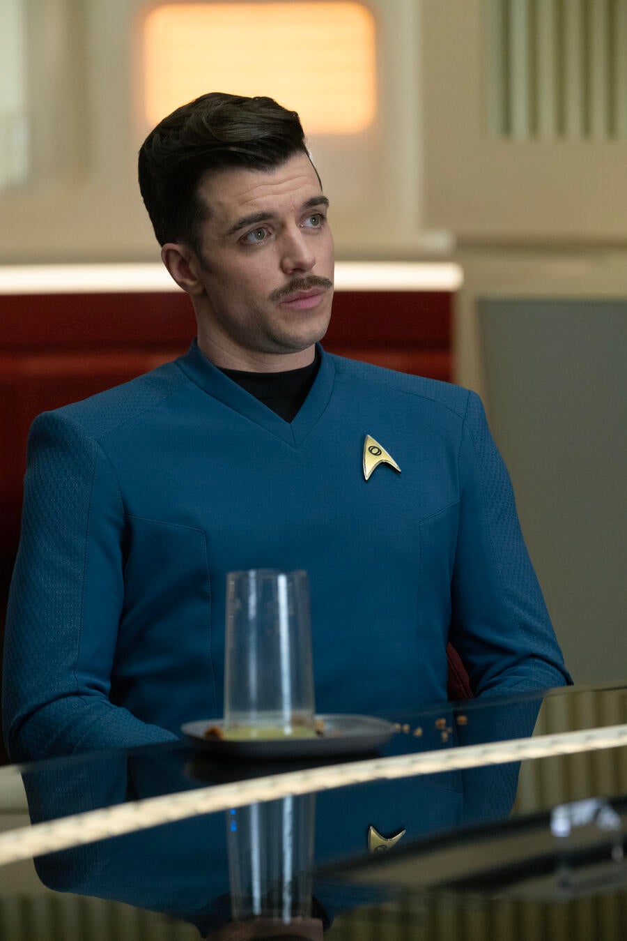 Close-up of Lt. Sam Kirk in the Ready Room next to his plate, glass, and crumbs in &#x27;Charades&#x27;