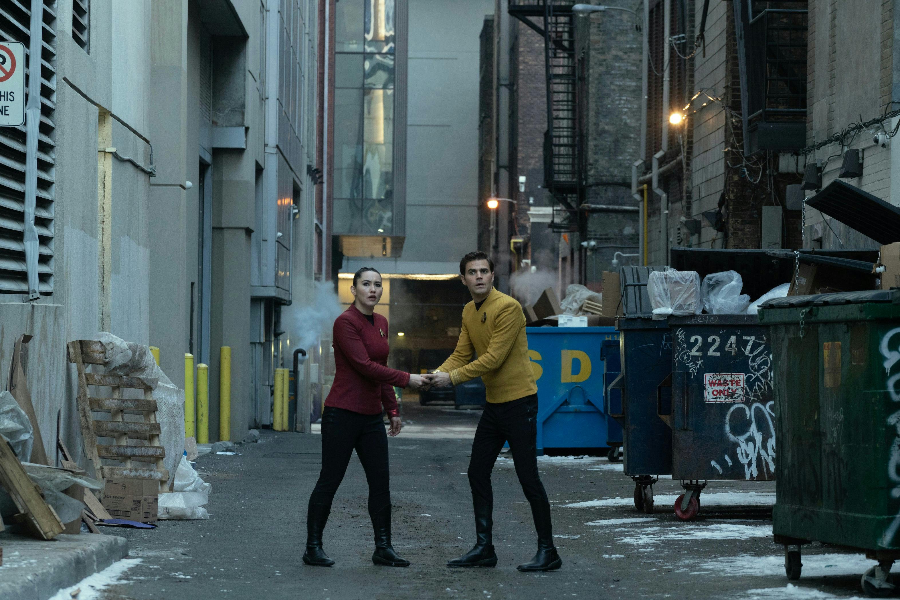 James Kirk and La'An both grip the same device in city alley near graffitied garbage bins in 'Tomorrow and Tomorrow and Tomorrow'